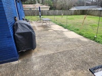 a backyard with a grill and a blue cover