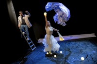 a man and a woman in a white dress on a ladder