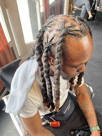 a man with dreadlocks sitting in a chair