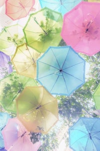 many colorful umbrellas are floating in the air