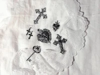 a white lace with a cross and other items on it