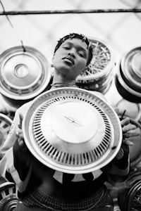 a black and white photo of a man holding a metal plate