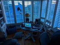 a room with a desk, chairs, and a laptop