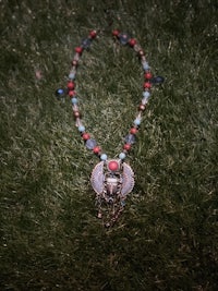 an egyptian necklace laying on the grass
