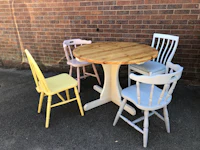 four chairs and a table in front of a brick wall