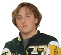 a young man wearing a varsity jacket