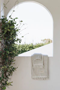 a white towel hanging on a window sill