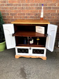a white tv stand with a bottle of wine on it