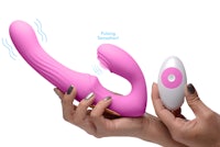 a hand holding a pink vibrating toy