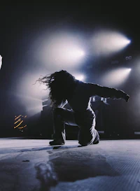 two dancers on stage in front of a bright light