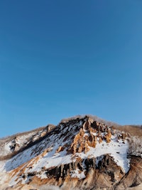 a hill covered in snow with a blue sky