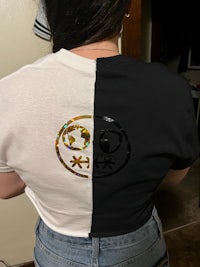 a woman wearing a black and white t - shirt with a smiley face on it