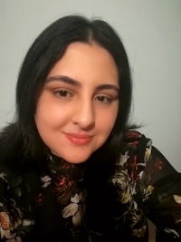 a woman in a floral shirt is posing for a photo