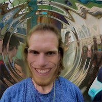 a man in a blue shirt with a smile on his face