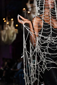 a woman wearing a netted dress on a runway