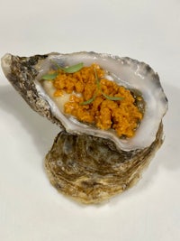 an oyster with a sauce on top of it
