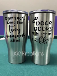 two stainless steel tumblers with the words today's goal keep the books tiny hummus alive