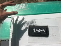 a person holding a piece of plastic with the word echo on it
