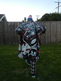 a person standing in a grassy area with a kite