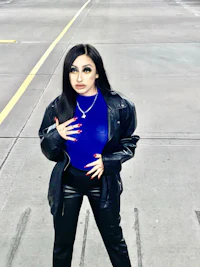 a woman in black leather pants and a blue top