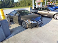 a black audi tt parked at a gas station