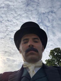 a man wearing a hat and a mustache