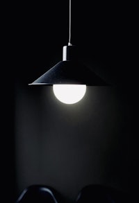 a black and white image of a lamp hanging in a dark room