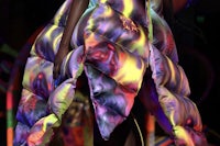a woman wearing a colorful puffy jacket on the runway