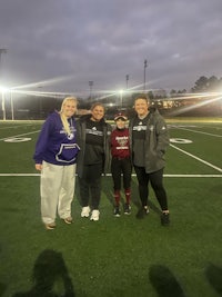 three softball players posing for a picture on a field