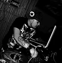 a black and white photo of a dj with tattoos