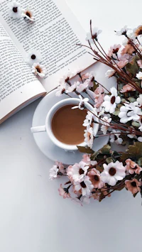 a cup of coffee and a book on a white table