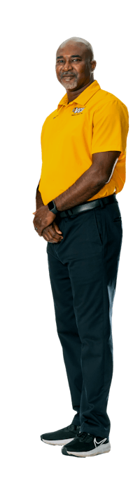 a man wearing a yellow shirt and black pants