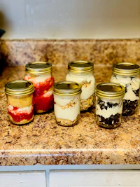 four jars of desserts sitting on a counter