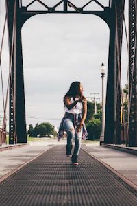 a woman jumping over a bridge