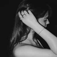 a black and white photo of a woman with her hands on her head