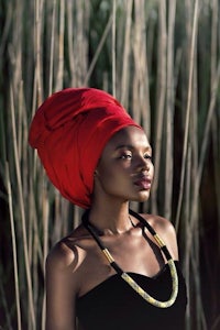 a young african woman wearing a red turban