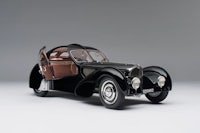 an old black sports car is shown on a grey background