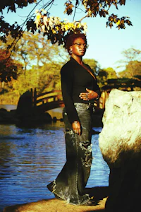 a woman standing next to a body of water