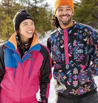 a man and a woman are smiling in the snow
