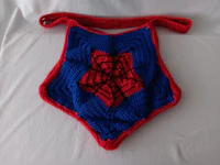 a crocheted spider - man bag on a bed
