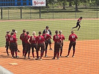 a group of softball players standing on a field