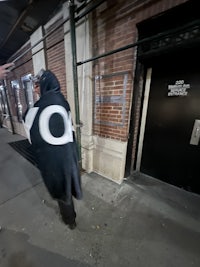 a person walking down the street in a black coat