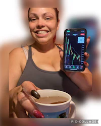 a woman holding up a cell phone with a stock chart on it