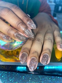 a woman's nails with glitter on them