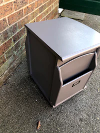 a grey nightstand with a drawer on it