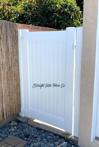 a white wooden gate in front of a house