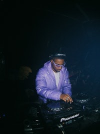 a man in a purple jacket playing a dj set