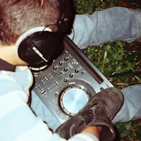 a man sitting in the grass with headphones on