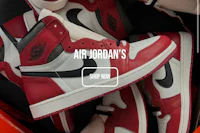 a pair of red and white air jordans in a box
