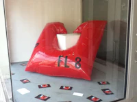 a red inflatable sculpture sits in a window
